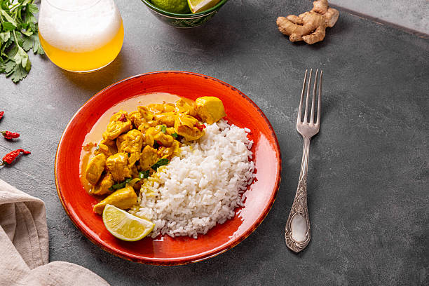 Chicken in curry sauce and rice on grey background, Indian food. High quality photo