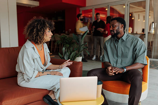 istock Two young professionals discussing a project in a modern office space 2228797236