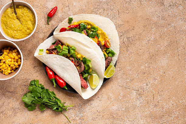 istock Mexican tacos, tortilla with beef, vegetable sauce, corn and tomatoes on the light background top view copy space for text 2228797899