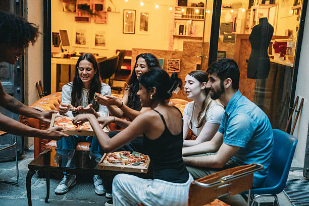 istock Young adults enjoying pizza together after work 2228800969