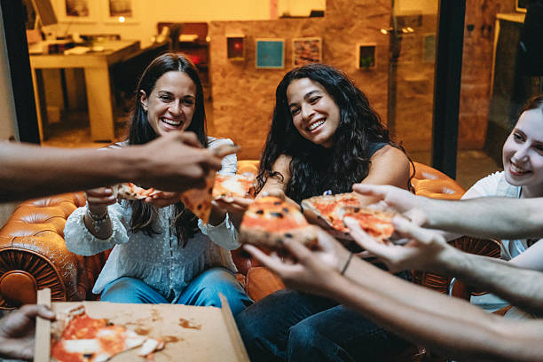 istock Coworkers sharing pizza slices during a break in the office 2228800974
