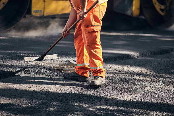 istock Construction worker working on a new asphalt layer on a public street. 2228801156