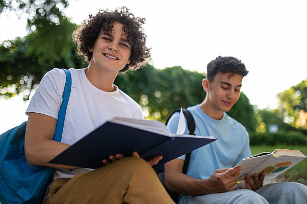 istock Two teens sitting in the park and studying together 2228801566