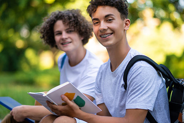 istock Two teens reading books together and looking enjoyed 2228801635