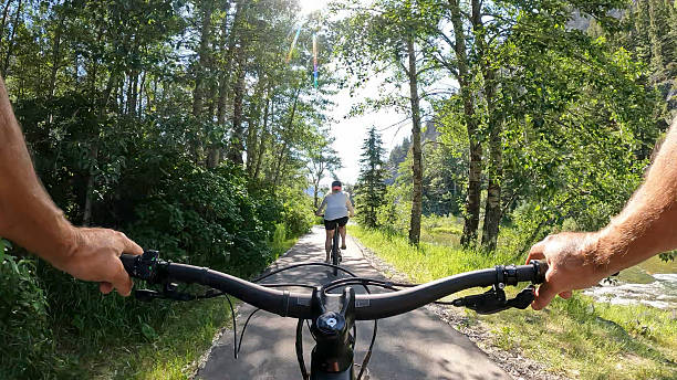 istock POV to woman riding bicycle on river pathway 2228802348