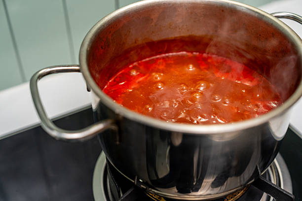 istock Rich tomato sauce simmer gently in a pot coat pasta. Thick vibrant tomato sauce bubbles in a pan filling the kitchen. Homemade tomato sauce bubbling beautifully on the stove awaits its pasta pairing 2228803399