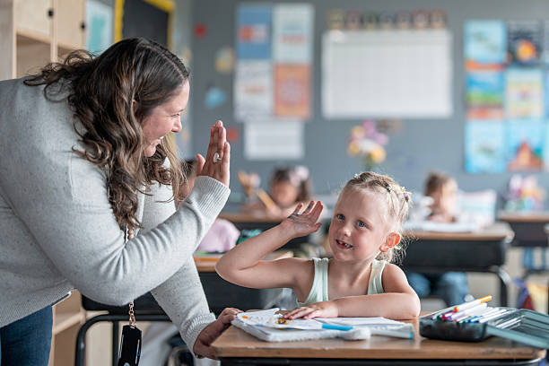 istock Teacher Encouraging Student With High-Five in a Bright Classroom 2228803460