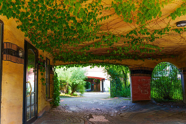 Darmstadt, Germany - June 18, 2025: Vibrant entrance view of the Waldspirale residential complex featuring unique architectural design, lush ivy-covered walls, and a serene atmosphere in Darmstadt.