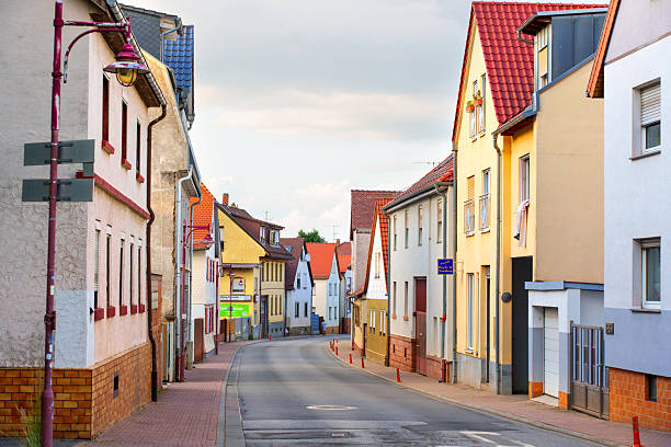 Rossdorf, Germany - June 23, 2025: Charming street view featuring vibrant buildings, red roofs, and a quiet road in Rossdorf, Germany during the golden hour.