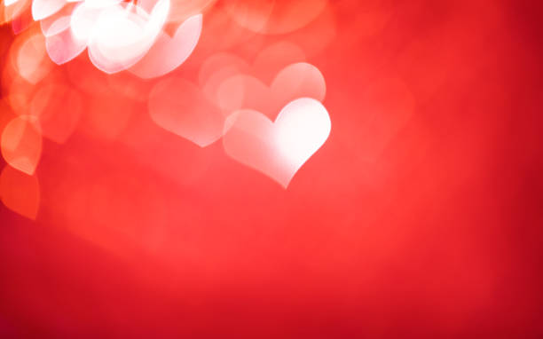 Defocused red background with heart shaped bokeh for Valentine's Day