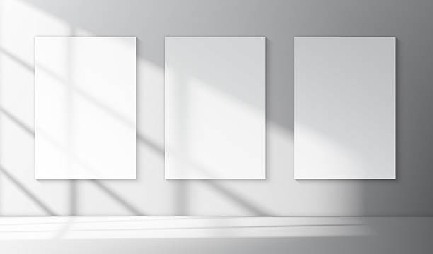 Vector white poster mockup or template Realistic vector mockup of three white vertical A4 poster with soft shadows of window inside empty minimalistic interior. Print or product presentation template prototype stock illustrations