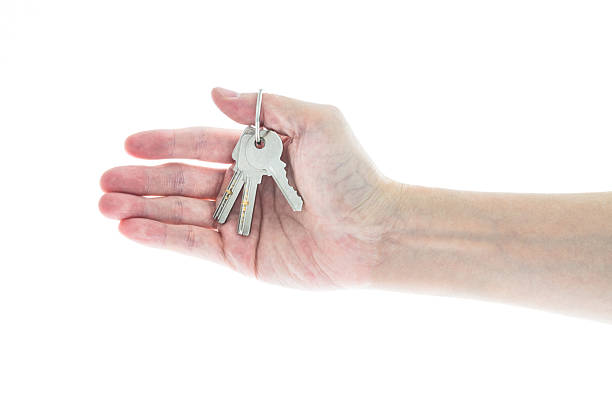 Woman hand holding keys on white background