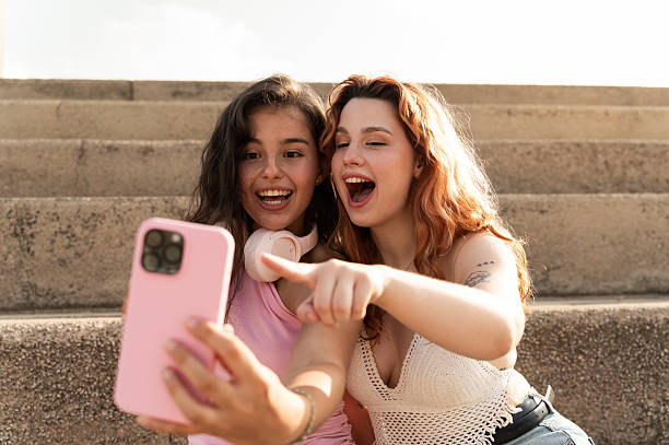 istock Two young women taking a selfie while sitting on stairs and having fun 2228810714