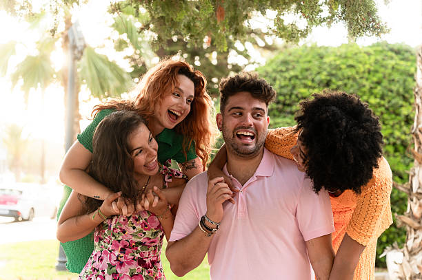 istock Young tourists having fun on piggyback ride in park 2228812860