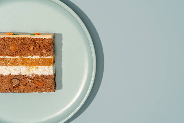 istock Bento cake slice featuring layers of carrot, orange, and mango, beautifully arranged on a light green plate, showcasing vibrant colors and textures for a delightful dessert experience 2228813895