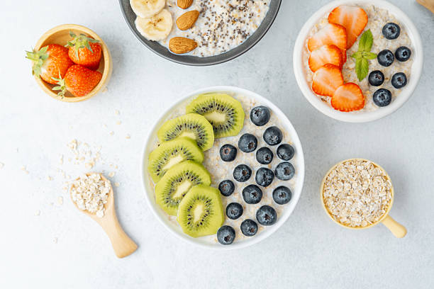istock Oatmeal breakfast bowls with fruits and grains on white surface 2228815977