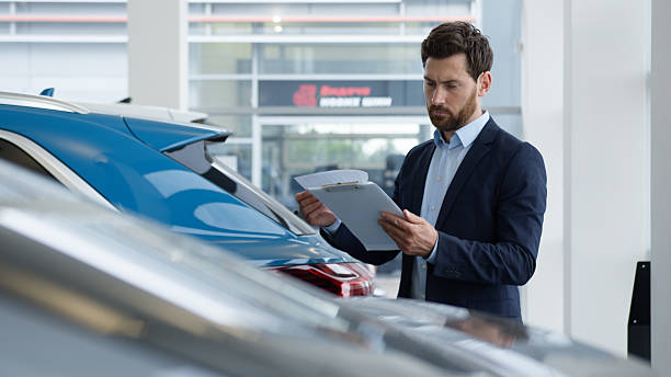 istock Caucasian man reading documents manager salesman consultant advisor specialist work clipboard car auto automobile dealer male businessman business seller agent checking papers guy electric transport 2228816209