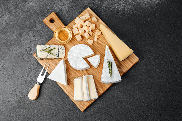 istock Cheese platter with various selections and honey served on a wooden board 2228816323