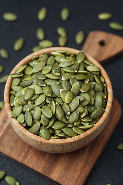 istock Pumpkin seeds in wooden bowl 2228816632