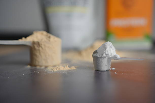 istock Scoop of Creatine and Protein Powder with Packaging in Background 2228821122