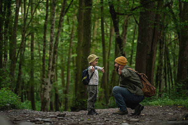istock Father and Son Enjoying a Forest Adventure Together Amidst Lush Greenery 2228834211