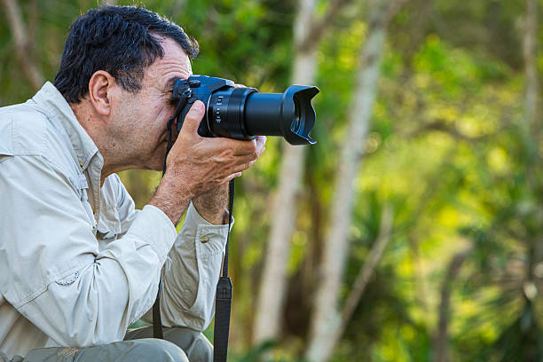 istock Hispanic mature man taking a picture with mirrorless camera in the forest 2228838661