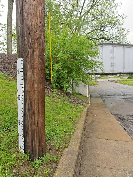 istock Stream river staff flood gauge on pole next to train bridge 2228838895