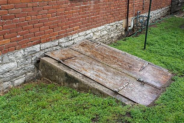 Weathered bulkhead door into colonial period brick house basement. Stone foundation cellar access in historic French colonial town of Ste Genevieve Missouri.