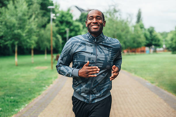 istock Smiling man jogging outdoors in the park. 2228840789