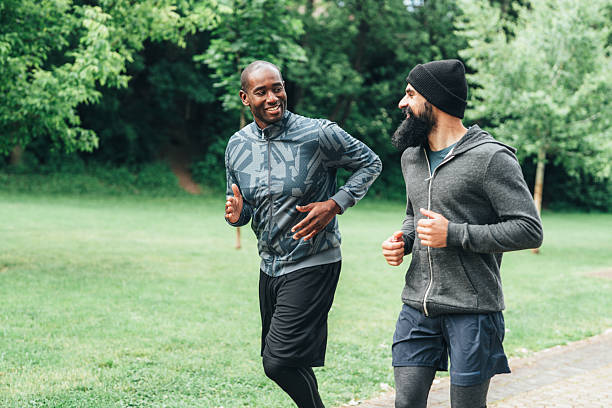 istock Cardio training outdoors. Happy athletes having fun while running together in nature. 2228840808