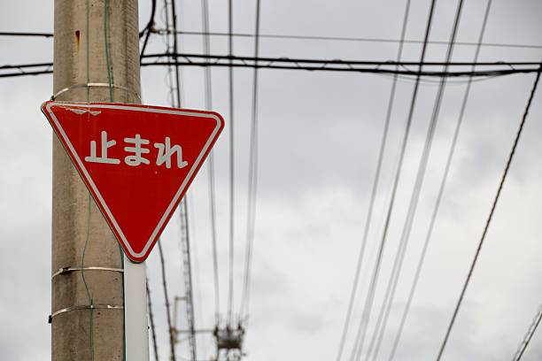 Japanese stop signs and electric poles, symbols of road safety. Translation: stop.