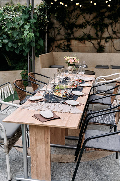 istock Elegant Outdoor Dining Table Set for a Memorable Gathering Surrounded by Lush Greenery and Warm Ambiance Ideal for Intimate Celebrations or Family Dinners 2228841587
