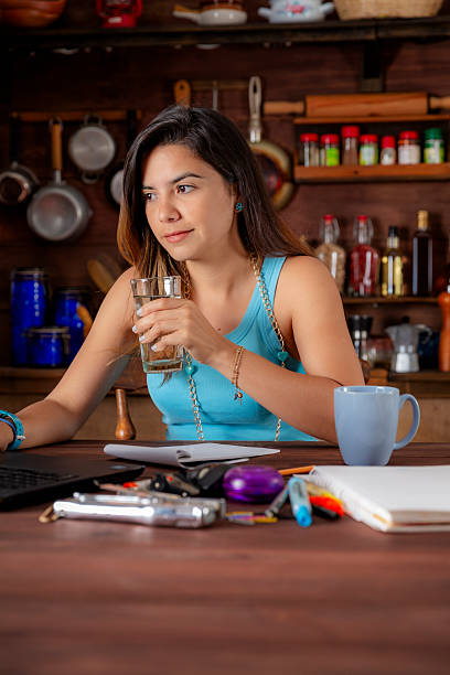 istock Hispanic young woman working in the kitchen and using laptop at home office 2228841769