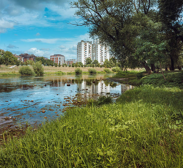 Life by the river, landscape of the river with buildings in the distance, summer season. Cacak town, West Morava river, Serbia.
