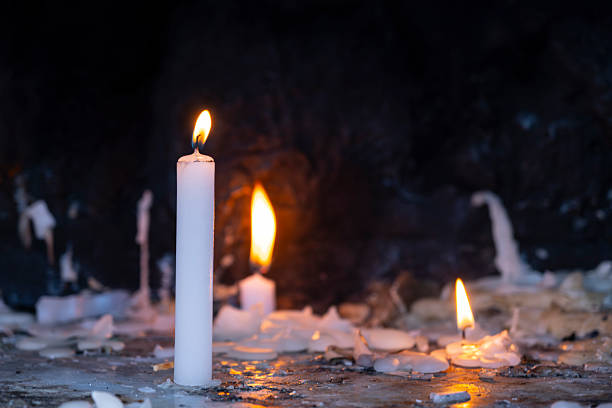 Candle lighting area in a church. Spiritual atmosphere. Prayer candles burning inside a historic church. Lit candles in church. Symbol of faith and hope.