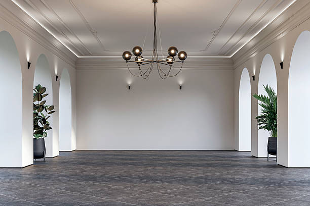 istock Modern empty interior with elegant arched openings, decorative ceiling molding, chandelier and decorative potted plants on dark gray tiled floor 2228844913