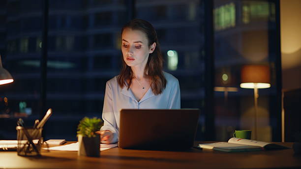 istock Woman employee working late browsing laptop handling documents in office closeup 2228844995
