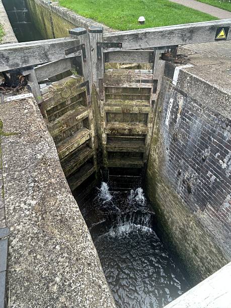 istock Old Canal Lock Gate With Water Flowing and Rustic Wooden Structure 2228845774