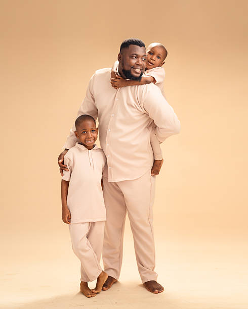 istock African father smiling with sons in affectionate studio moment 2228847360