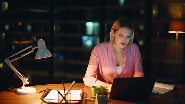 istock Online student noting information from laptop sitting night workplace closeup. 2228847535