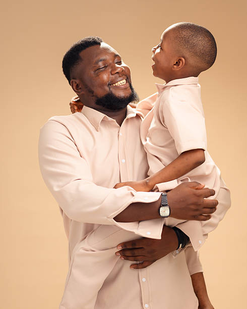 istock African father and son share joyful embrace in studio portrait 2228849696