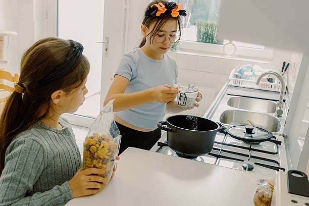 istock Two sisters are cooking pasta in the kitchen. 2228849849