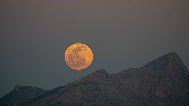 istock Golden Full Moon Rising Over Mountain Peaks at Twilight – Series 2/4 2228850189