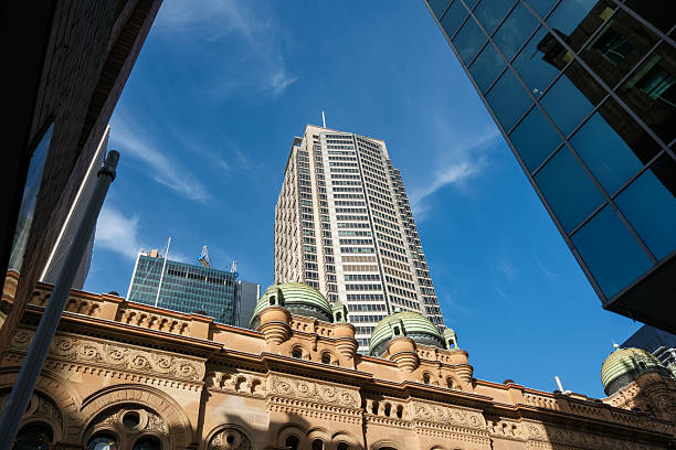 istock Tall modern office building rising from behind a Victorian style building 2228851512