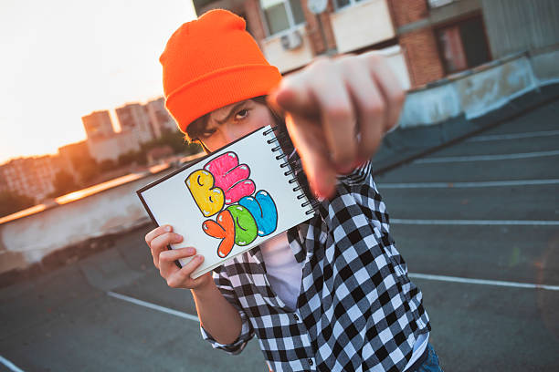 istock Child holding “be you” sketch, pointing at camera at sunset 2228857524