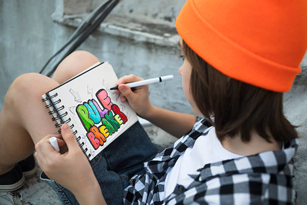 istock Child drawing “rule breaker” message in sketchbook 2228857545