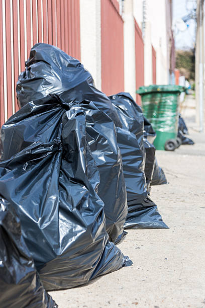 istock black garbage bags stacked on the street 2228860603