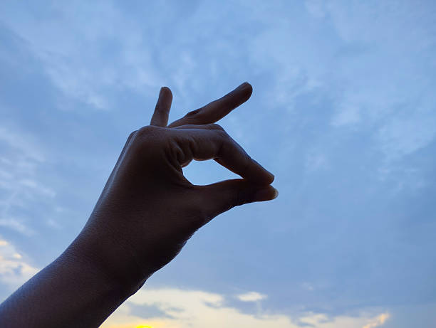 istock OK Hand Gesture Silhouette Against a Serene Morning Sky 2228862822