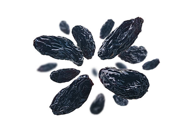 Dark grapes levitate on a white background.