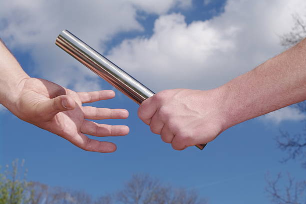 istock Two people are holding hands and one is holding a baton 2228868407